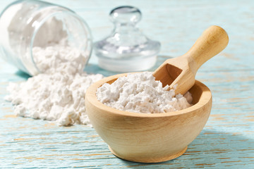 Wooden bowl with corn starch close-up  on a wooden table.