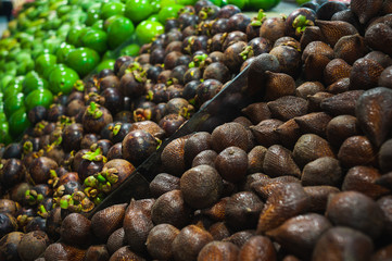 Plenty of fresh Salak fruits on a counter in a market