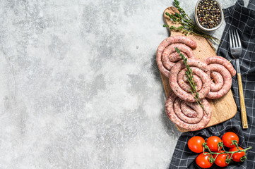 Traditional raw spiral pork sausages. Gray background. Top view. Copy space