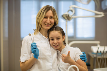 Fototapeta premium Schoolgirl patient and woman dentist, portraite in dental clinic.