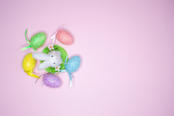 Colorful painted eggs and easter bunny on pink background