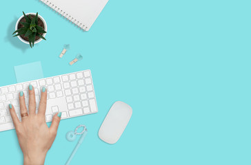 Flat layout of workplace with woman hand on keyboard