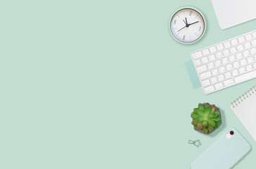 Flat layout of workplace. Succulent, keyboard and empty notepad on mint green background