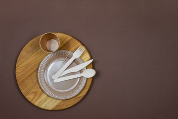 Zero waste, environmentally friendly, disposable, cardboard, paper utensils on a brown background. View from the top. Place for an inscription.