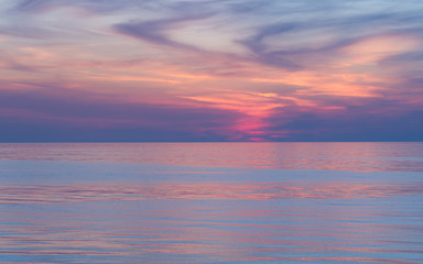 Fototapeta na wymiar Pink sunset on the sea. Twilight Dusk. Beautiful clouds over the calm sea.