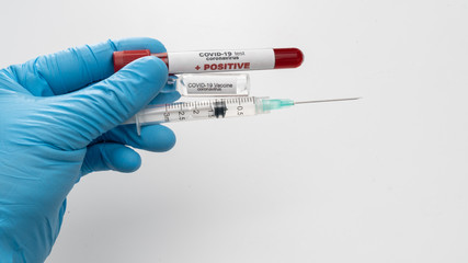 Doctor holds COVID 19 Coronavirus vaccine in his hand, infected blood sample in the sample tube, Vaccine and syringe injection It use for prevention, immunization and treatment from COVID-19