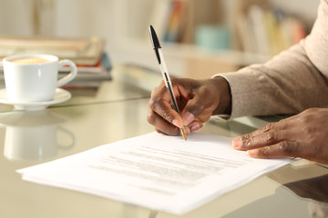 Black man hands singing contract on a desk