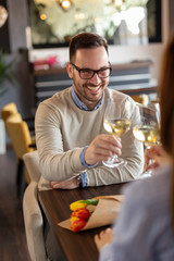 Couple making a toast while on date in restaurant