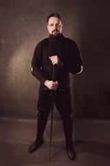 A man with a beard with a sword. Historical European Martial Arts, armor and weapons for practice.
