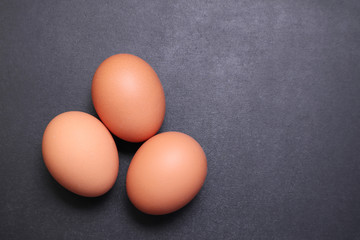 Chicken eggs on a black textured background.