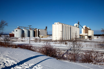 Obraz premium Winter scenic of grain storage tanks and elevators in the snow near the shoreline of Lake Superior. Superior Wisconsin WI USA