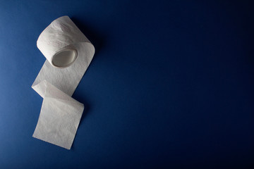 Toilet paper on a blue background top view. The concept of deficit and crisis. Coronavirus and epidemic virus. Horizontal orientation. The view from the top. Copy space. Space for text