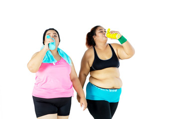 Obesity women drink water with bottles in studio