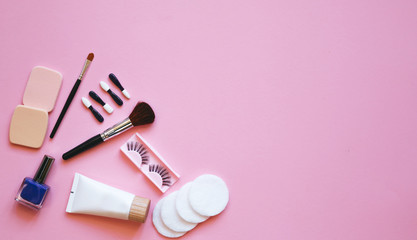 Professional makeup tools. Makeup tools brushes, eyelashes, nail polish, ,cotton pads, applicators on pink  background. Cosmetics for beauty. Top view with copy space Flat lay.