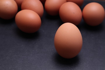 Chicken eggs on a black textured background.