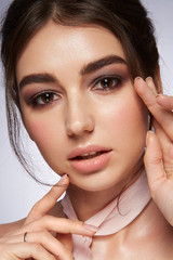 Glamour portrait of beautiful woman. Fashion shiny highlighter on skin, sexy gloss lips make-up and dark eyebrows