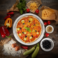 Flatlay of Italian pizza on wooden background. Rustic homemade pizzas with salami, bacon,  cheese, eggs and raw vegetables on shabby wooden background. Healthy vegetarian fungi pizza