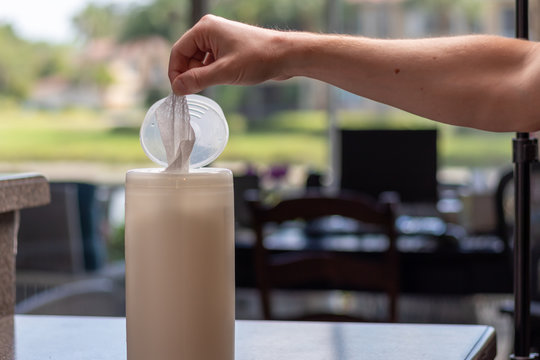 Disinfecting Wipes Being Taken Out Of Plastic Container By Person The Disinfecting Wipes Kills Bacteria And Viruses. 