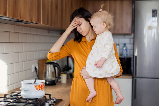 Housewife in the kitchen tired of stress annoyed. Weekdays moms female labor. Parenting real life authentic motherhood candid. Keep the household do not have time to do housework. Mess with baby