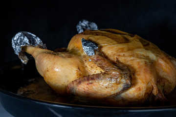 Freshly fried chicken from a home oven, on a black background, close-up, shallow depth of field. Concept, home cooking.