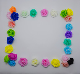  frame of multi-colored artificial roses on a white background. place for declaration of love or congratulations