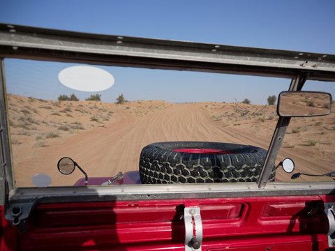 Driving through dunes in a vintage off-road vehicle