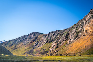 Fototapeta premium Shelter hidden in a valley lit by sun