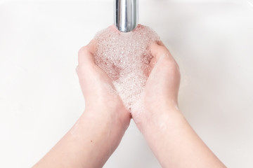Fototapeta premium Washing hands with soap under the faucet with water