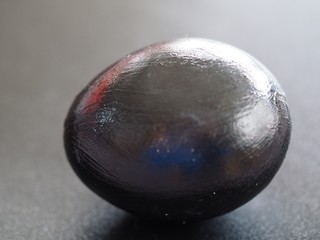 Minimalism Black Egg on Black Background with Light Reflections in Egg
