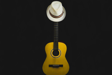 Guitar and hat in the dark. acoustic musical instrument. strings on the guitar neck