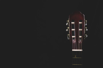 Guitar headstock on black background. acoustic musical instrument
