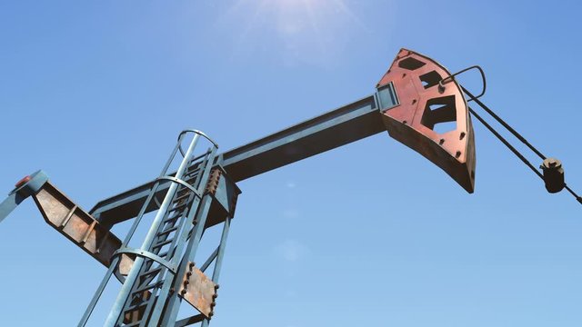 Low angle shot of oil pump jack pumping crude oil under clear blue sunny sky. Fossil fuel energy is the cheapest and the most profitable energy source in whole power generation industry.