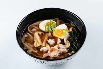 Ramen noodle soup with soy asparagus, hard boiled egg and prawns isolated on white for a menu