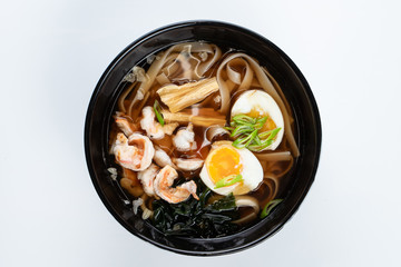 Ramen noodle soup with soy asparagus, hard boiled egg and prawns isolated on white for a menu