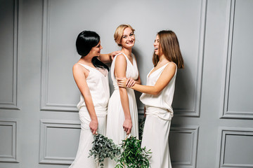 Bridesmaids in elegant white dresses in the studio