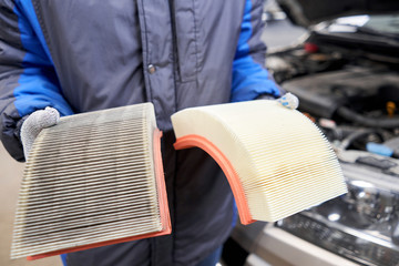 New and old dirty automotive engine air filter in the hands of an auto mechanic. Auto repair...