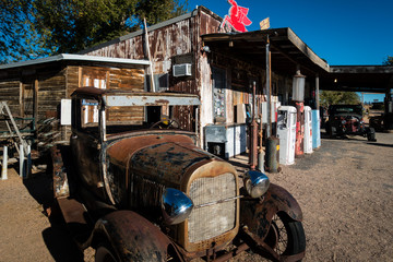 Rusty old car standing in front of historic gas station on Route 66 in Arizona