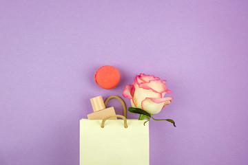 Female holiday present with rose and perfume on the background with place for text, holiday concept, tender spring mood