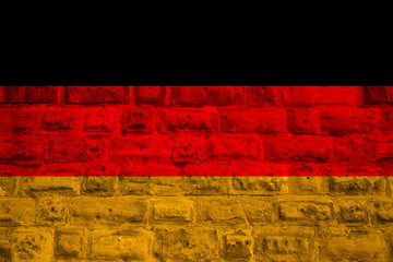 national flag of the modern state of Germany on an old historical stone wall, concept of business, tourism, travel, emigration, globalization