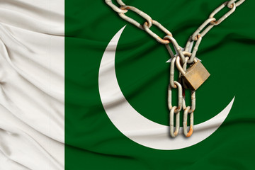 iron chain and lock on the silk national flag of Pakistan with beautiful folds, the concept of a...