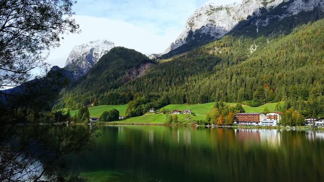 Idyllic panorama view of Hintersee lake with beautiful reflections of trees and house and Bavarian Alps and blue sky cloud in background, near Konigssee lake, Ramsau in Berchtesgaden, Bavaria, Germany