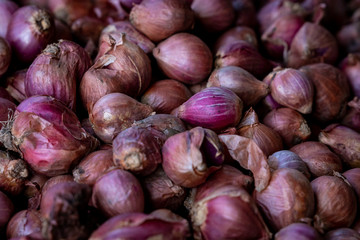 Colorful purple onions are one of the fresh produce products at an outdoor asian market in Bali, Indonesia.