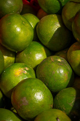 Colorful green limes are one of the fresh produce products at an outdoor asian market in Bali, Indonesia.
