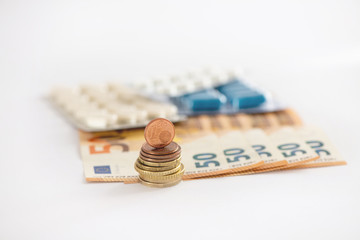 pills and money on white background