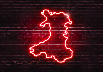 Neon sign on a brick wall in the shape of Wales.(illustration series)