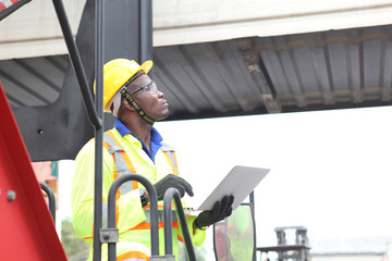 Close up of An African American handsome black engineer he is working in container box yard area