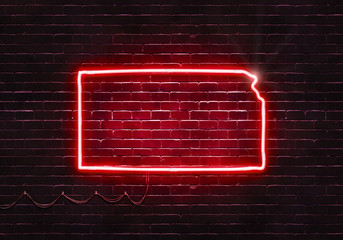 Neon sign on a brick wall in the shape of Kansas.(illustration series)