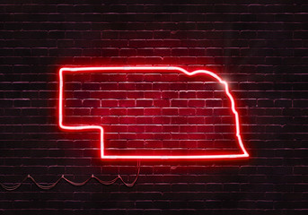 Neon sign on a brick wall in the shape of Nebraska.(illustration series)