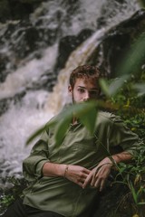 young man in the forest with waterfall background 