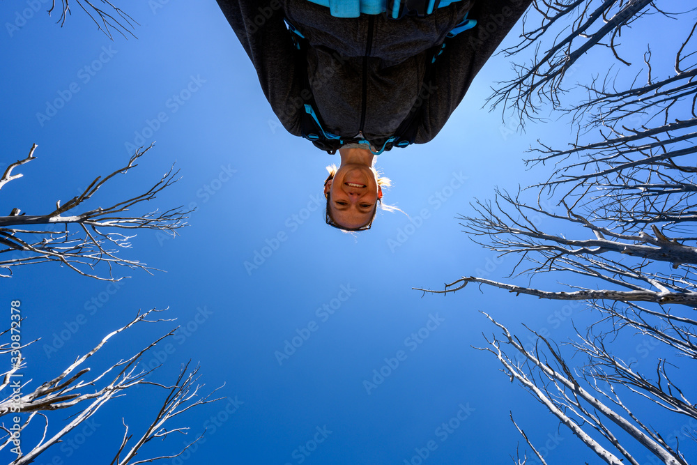 Poster Looking up at Smiling woman with bare trees